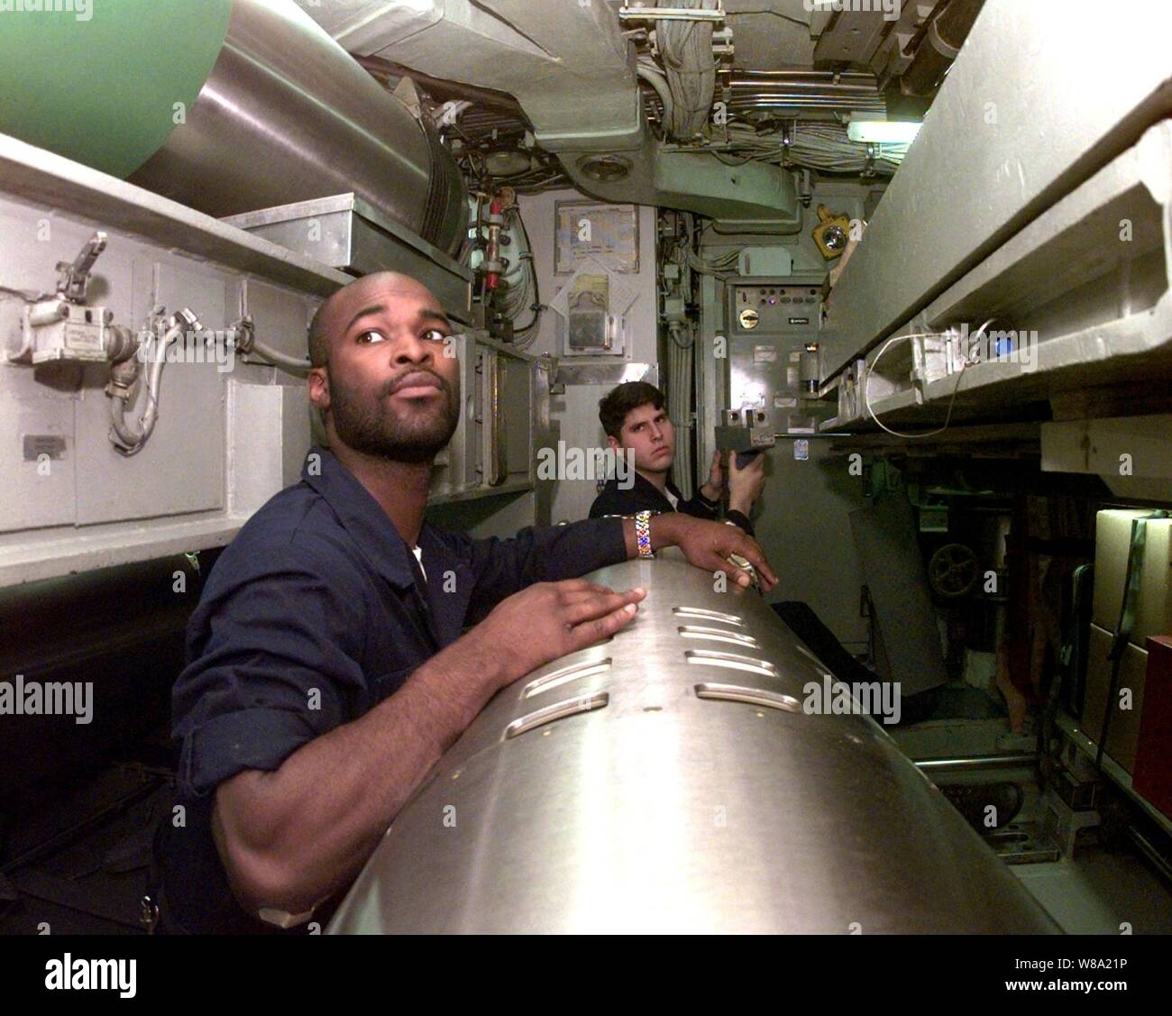 Seaman Daymond Jacobs (à gauche) et le Maître de 2e classe Jim Piatt attendre d'autres arrêtés au cours d'une pré-charge de l'inspection d'un missile de croisière Tomahawk dans la chambre des torpilles à bord du USS Norfolk (SSN 714) le 31 mars 1999. Le sous-marin d'attaque de classe Los Angeles est opérant dans la mer Adriatique à l'appui de l'opération Force alliée de l'OTAN. Banque D'Images
