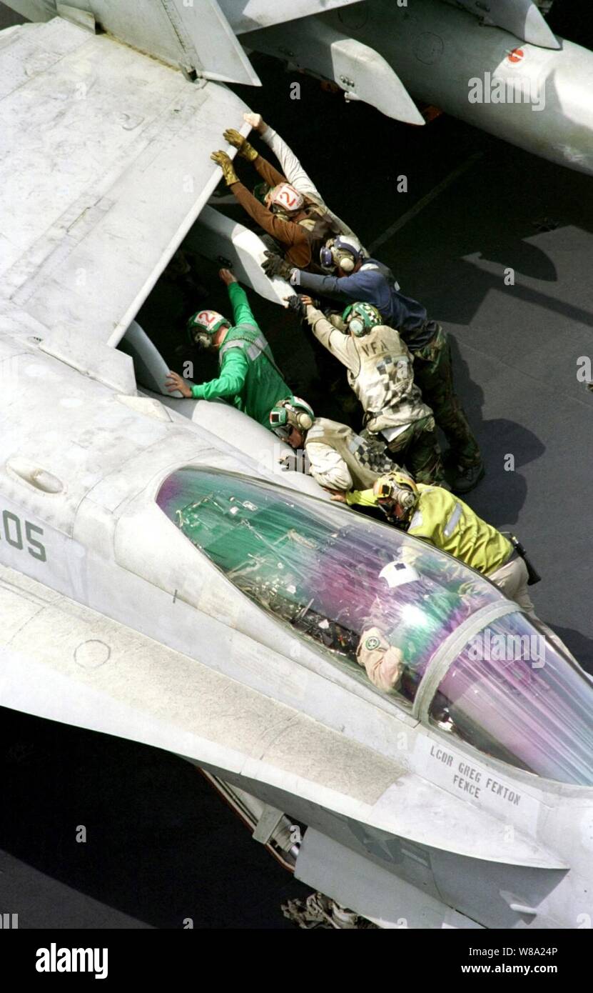 Les membres d'équipage de pousser un F/A-18C Hornet en position de retenue pour le poste de pilotage de l'USS Enterprise (CVN 65) le 8 avril 1999. L'entreprise et son escadre aérienne de transporteur 3 sont en service dans le golfe Persique dans le cadre de l'opération Southern Watch, qui est la coalition des États-Unis et l'application de la zone d'exclusion aérienne au-dessus du sud de l'Iraq. Banque D'Images