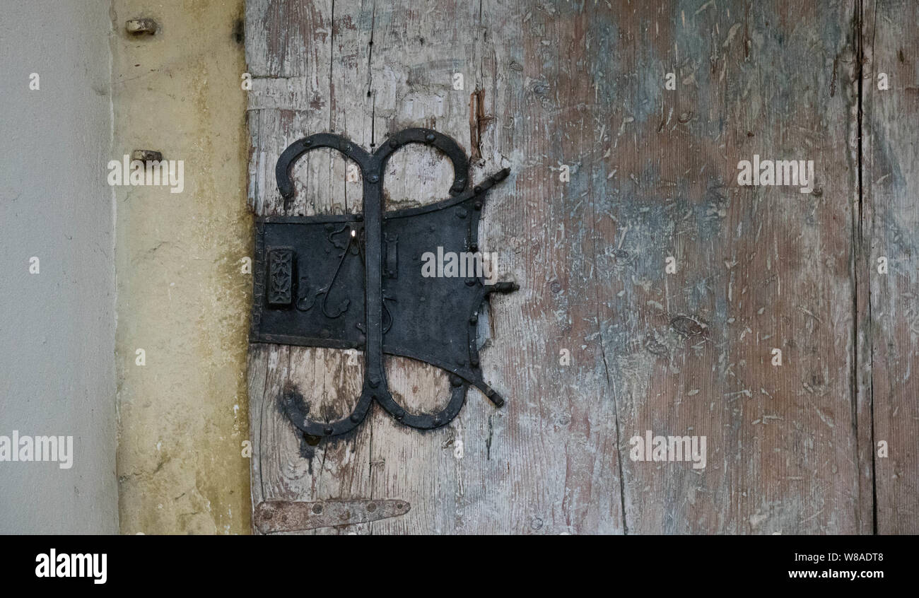 Porte en bois rustique avec poignée unique et un fond de couleur neutre. Banque D'Images