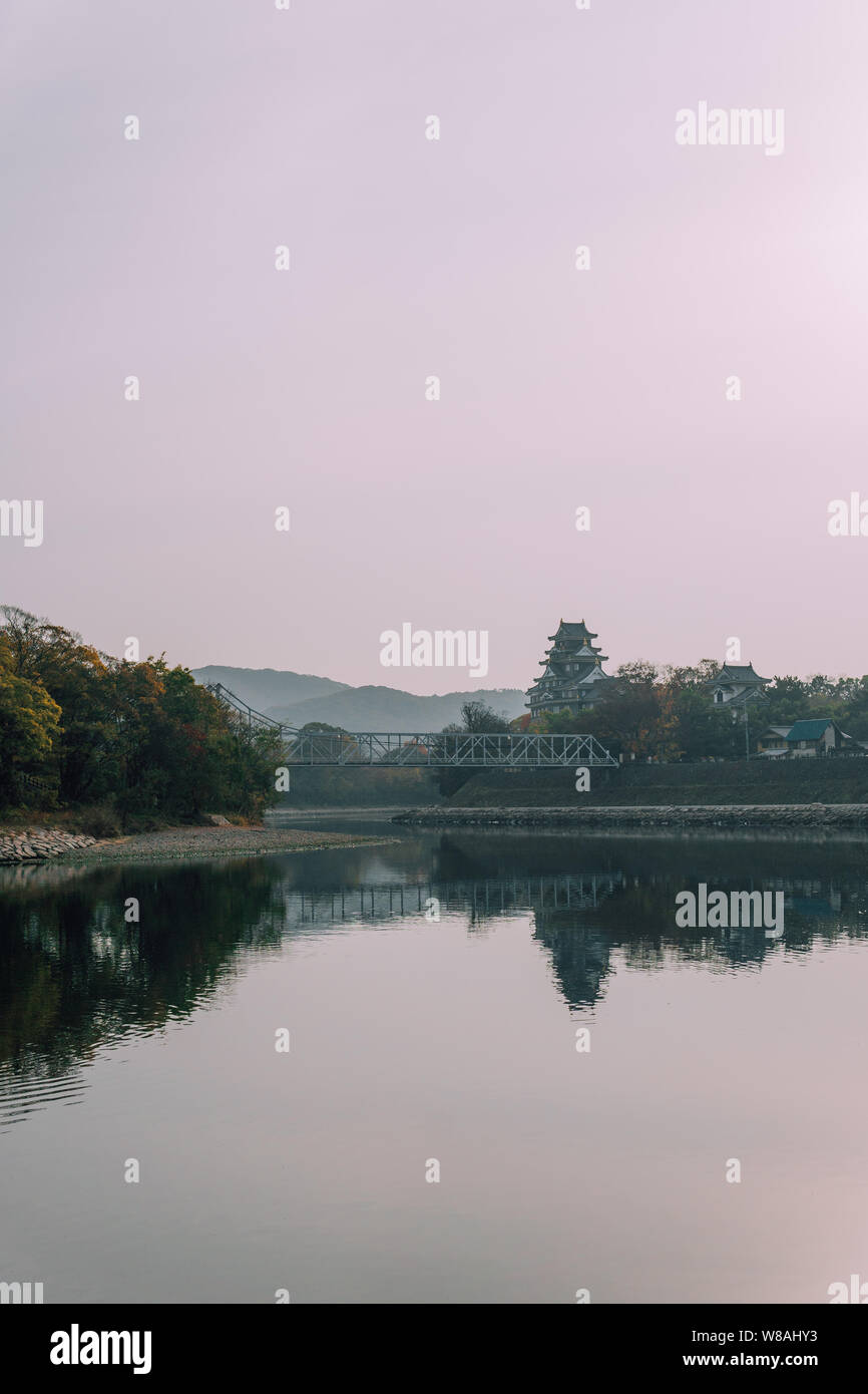 Okayama castle au cours aube lumière rose avec de l'eau reflets dans la rivière Asahi, préfecture d'Okayama, Japon Banque D'Images