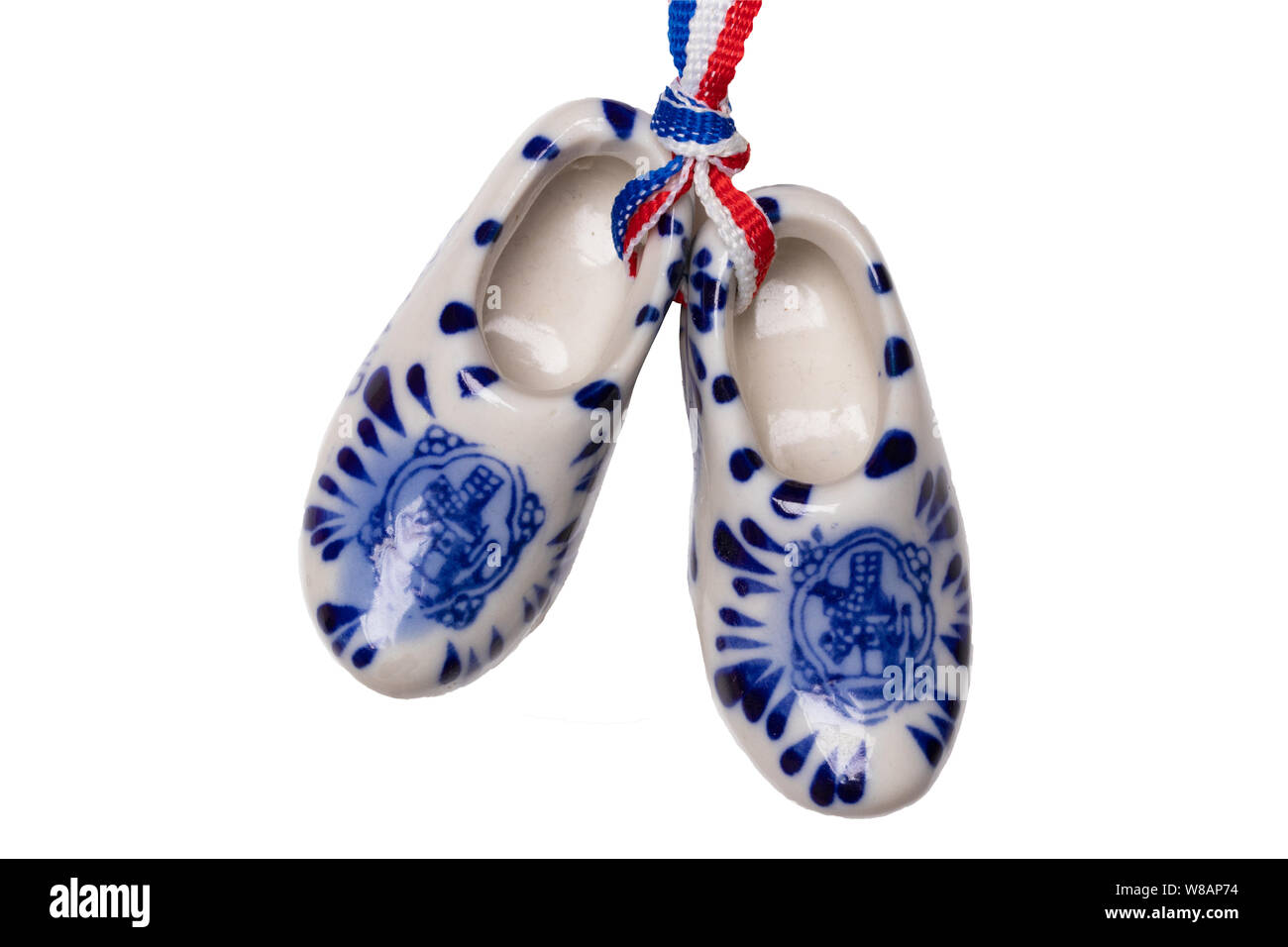 Sabots en bois de New Holland. Une paire de chaussures en porcelaine traditionnelle hollandaise avec un drapeau du ruban isolé sur un fond blanc. Souvenir d'Amsterdam. Macro. Banque D'Images
