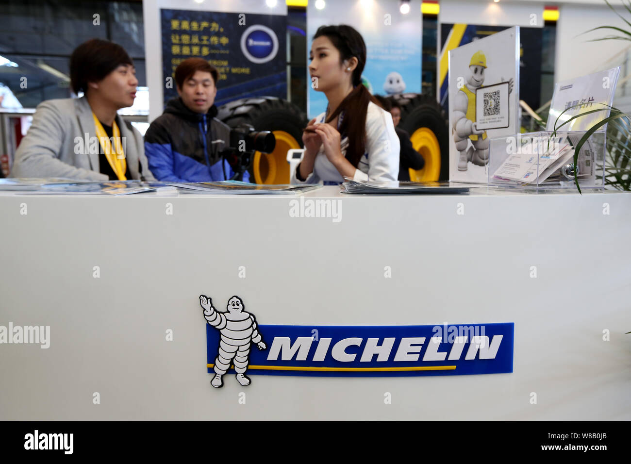 --FILE--employés chinois sont vus sur le stand de Michelin à la 7e Salon International des Machines de Construction, Machines de matériaux de construction Banque D'Images