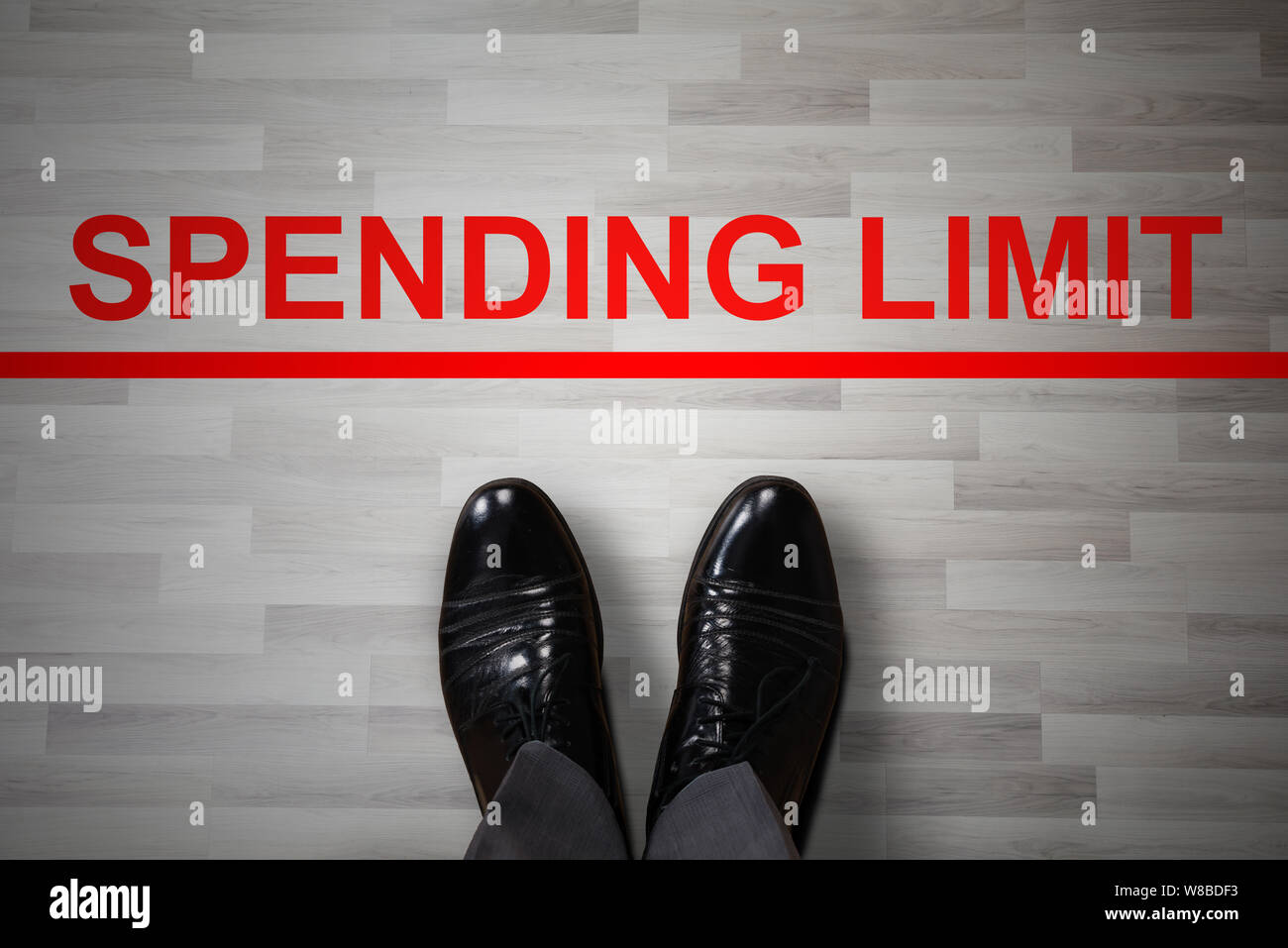 Le pied de l'homme dans des chaussures noires, debout près de la limite de dépenses Ligne interdit rouge Banque D'Images