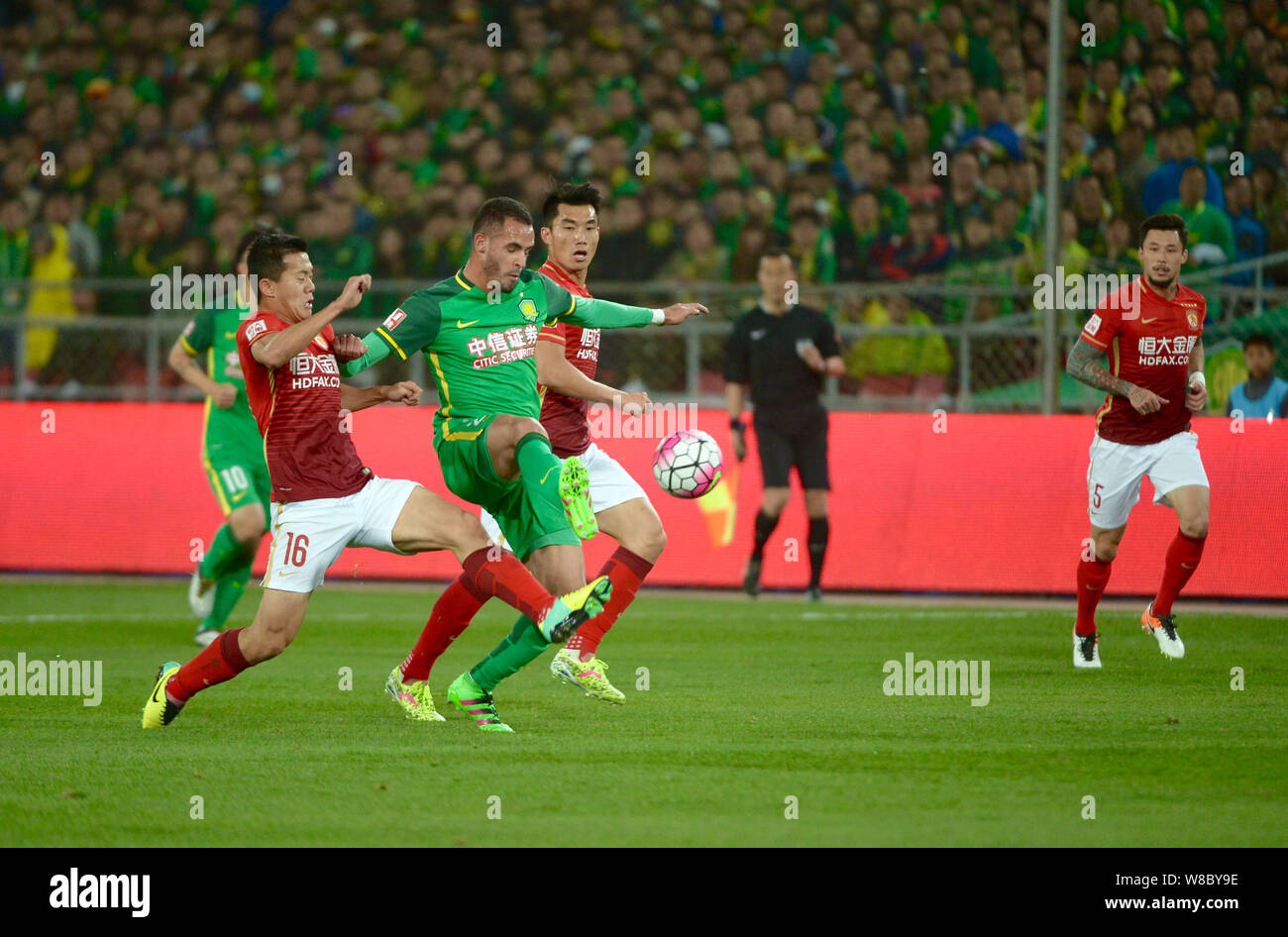 Renato Augusto de Beijing Guoan, deuxième à gauche, défis Huang Bowen, gauche, de Guangzhou Evergrande dans leur quatrième match de la fo chinois 2016 Banque D'Images