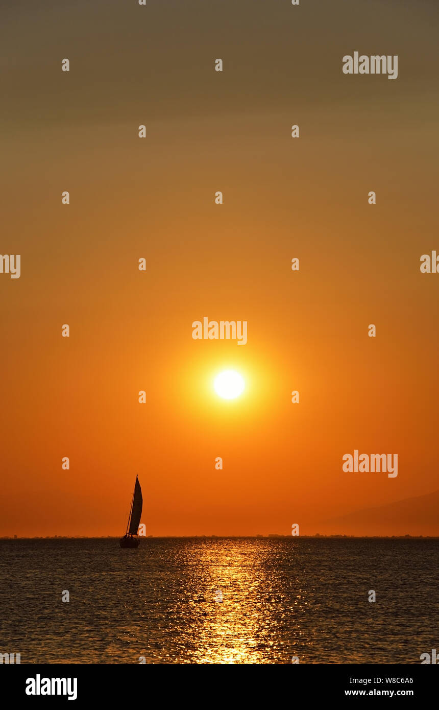 Silhouette de voilier au coucher du soleil jaune Banque D'Images