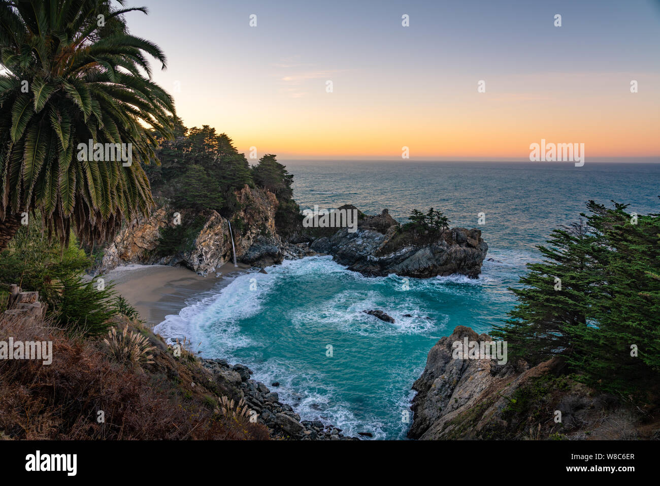 Large vue sur la cascade à McWay Falls verser sur la plage pendant le lever du soleil. Banque D'Images