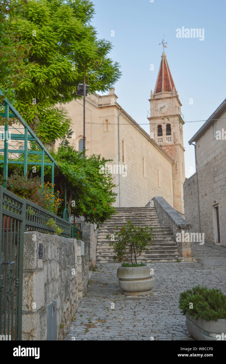 L'architecture en pierre de Postira ville dalmate avec en arrière-plan, l'île de Brač, Croatie Banque D'Images