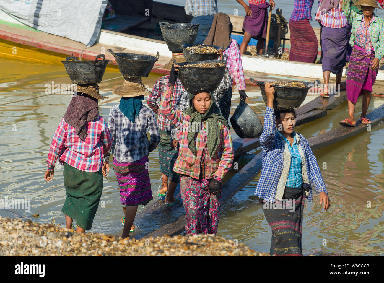 BAGAN, MYANMAR - le 23 décembre 2016 : les birmanes décharger une barge avec les cailloux de la rivière Banque D'Images