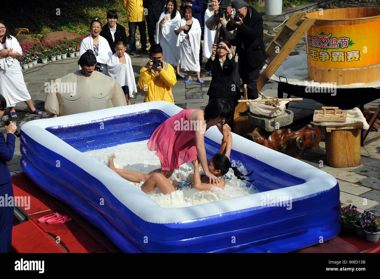 Les femmes qui participent à une compétition de lutte dans une piscine remplie de tofu et lait à une source d'eau chaude volcanique complexe à Fogang, comté Banque D'Images