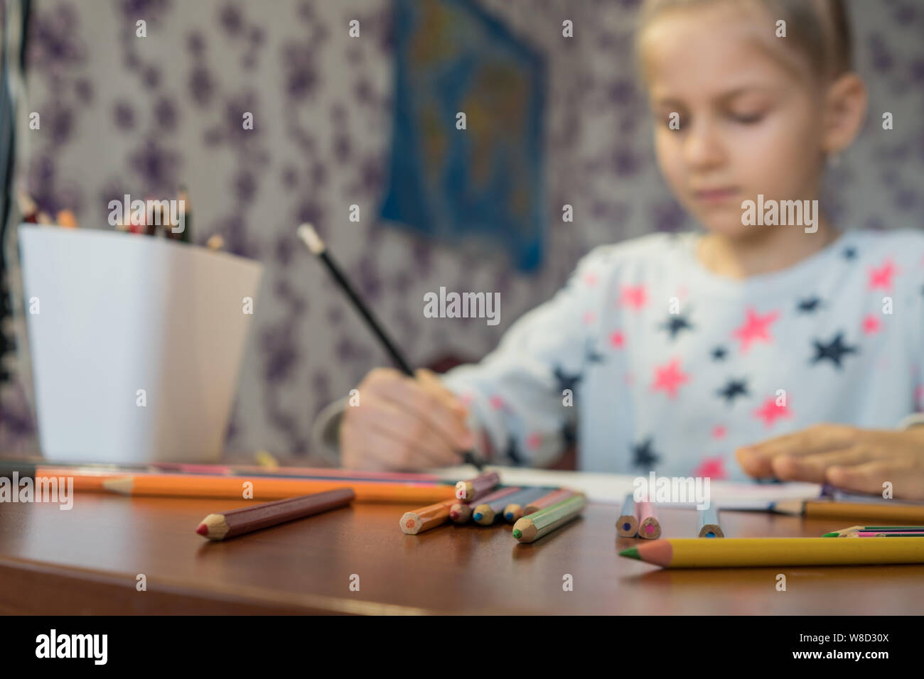 Attentifs enfant écrit avec des crayons sur l'album. Travail à domicile. La créativité des enfants. Banque D'Images