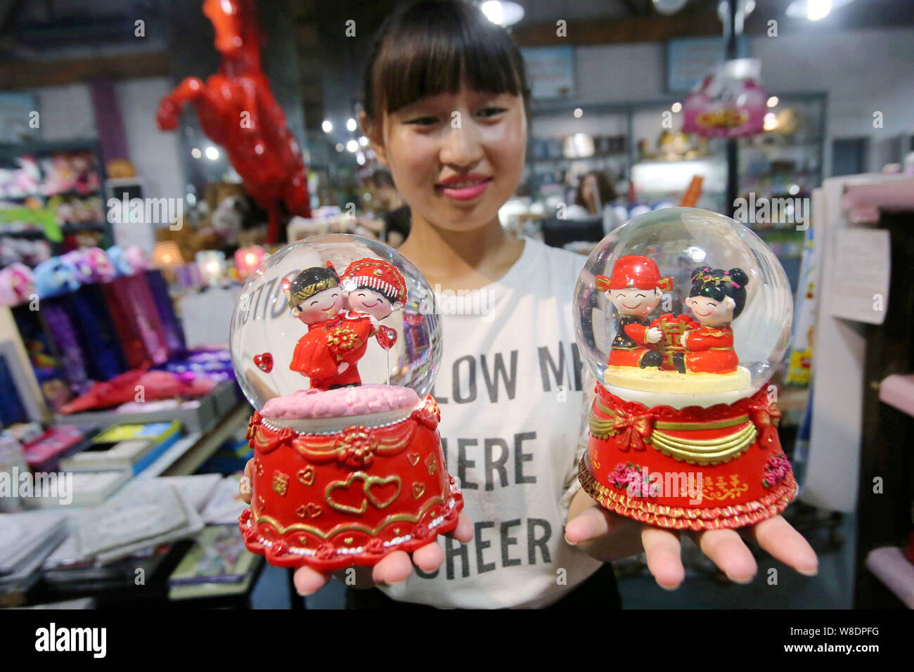Une vendeuse chinoise sur le thème de l'amour montre des boules de cristal pour le prochain Festival Qixi, aussi connu comme les Chinois, à la Saint-Valentin, dans une boutique d'artisanat dans Banque D'Images