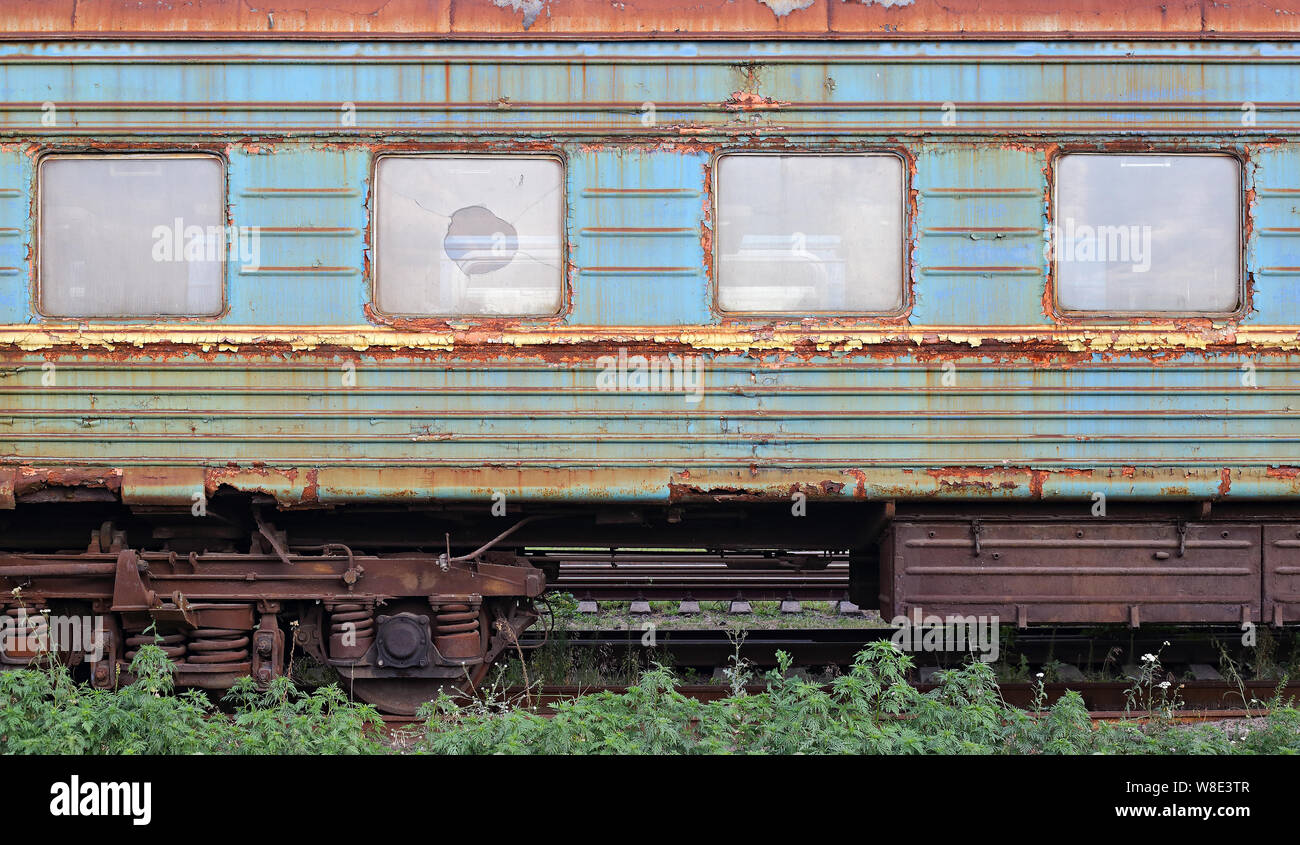 Transports - vue latérale sur le chemin de fer old rusty jeté voiture avec les vitres brisées. Banque D'Images
