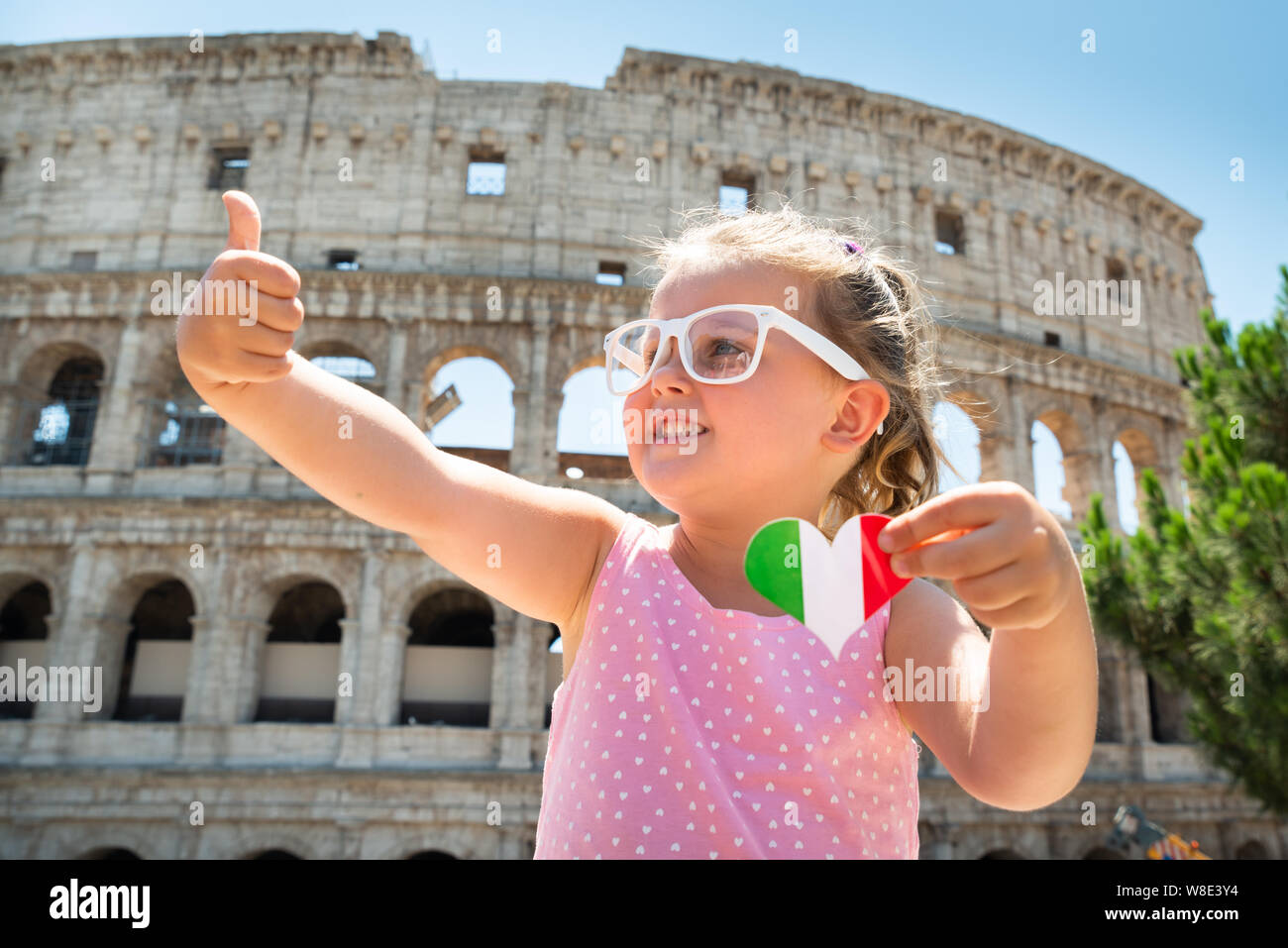 Drapeau Italien Girl Wearing Sunglasses, Holding Heart et Showing thumb up près de Colisée, Rome, Italie Banque D'Images