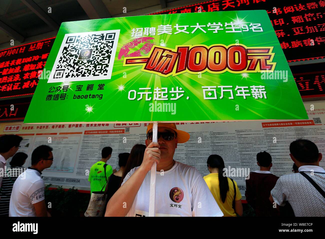 Un employé chinois d'un crocodile-produit des soins de santé liés à l'entreprise est titulaire d'un placard pour attirer des diplômés afin de gagner un emploi et 1 000 yuans par ki Banque D'Images
