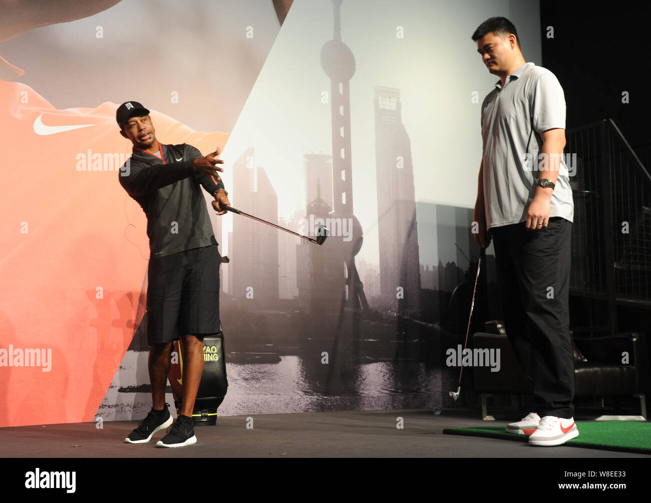 Tiger Woods de l'United States, gauche, indique à pris sa retraite de basket-ball chinois Yao Ming star pour jouer au golf au siège de Nike à Shanghai, Shanghai Banque D'Images