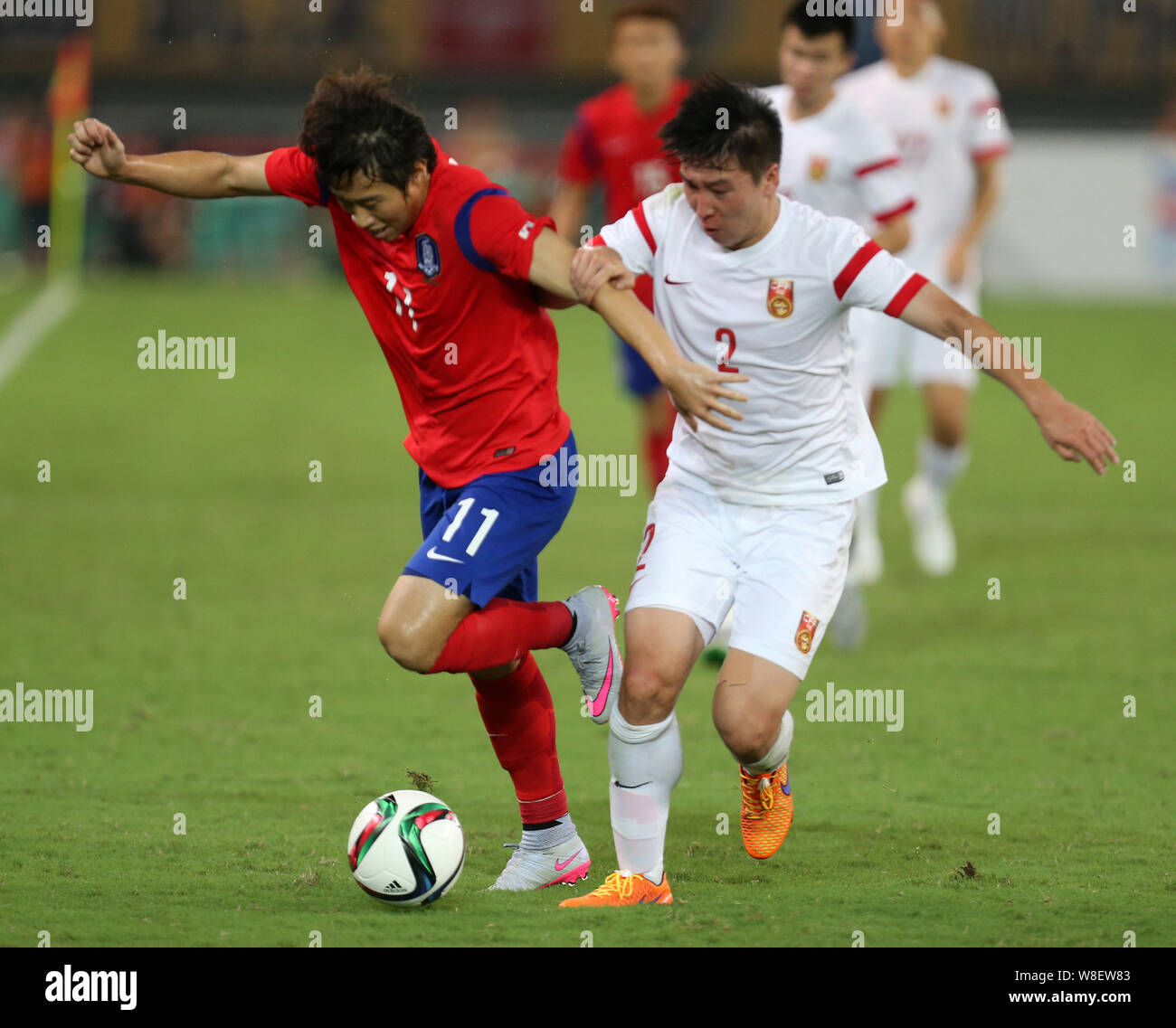 S'accrocher de Chine, droit, défis Lee Yong-jae de Corée du Sud lors de leur match de football de la coupe d'Asie de l'Est de 2015 à Wuhan, central Chi Banque D'Images
