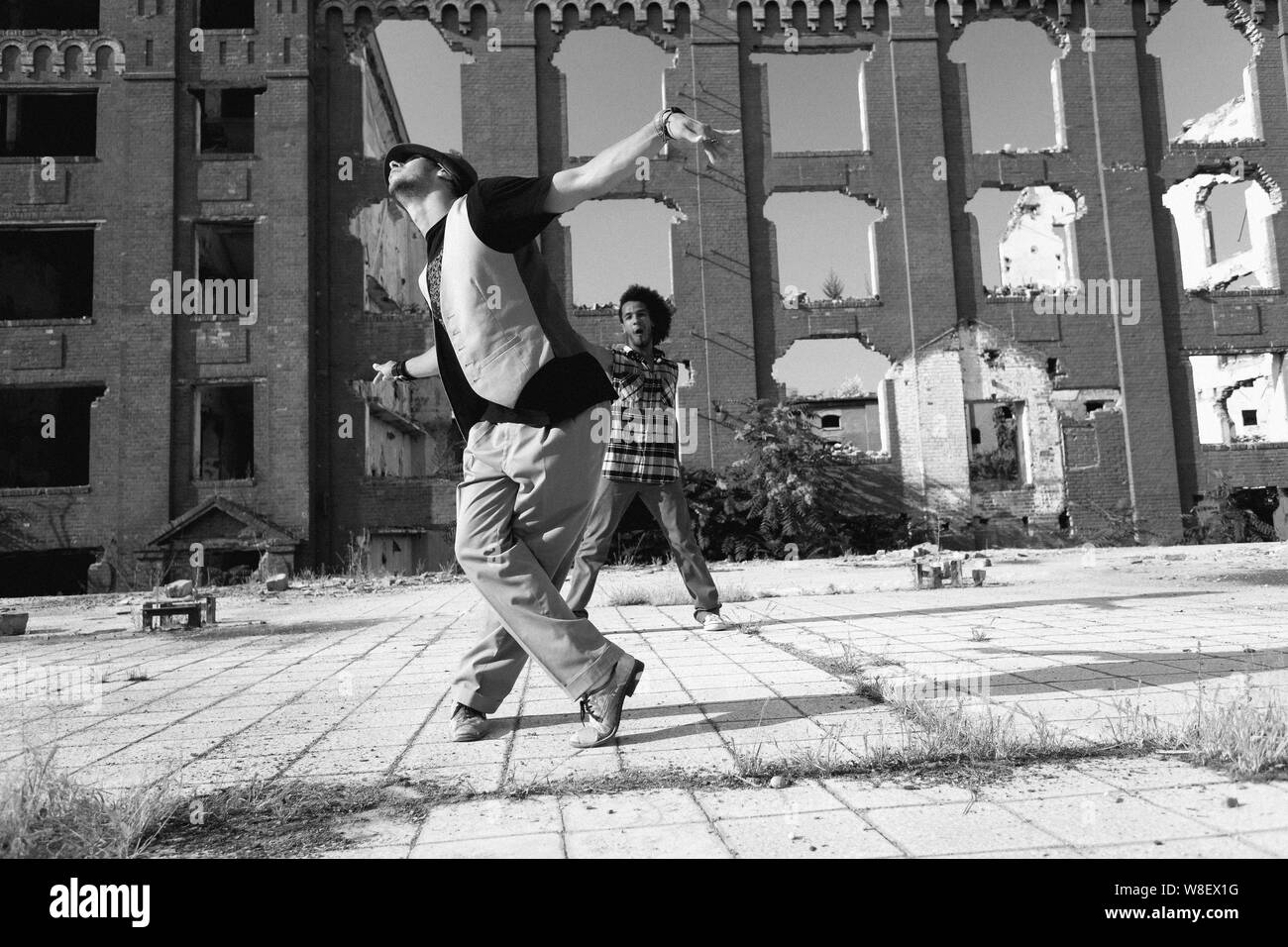 Les jeunes énergique de la scène hip hop street dancer sa routine dans une place urbaine vu par un jeune africain ami américain avec une coiffure afro curly Banque D'Images Les jeunes énergique de la scène hip hop street dancer sa routine dans une place urbaine vu par un jeune africain ami américain avec une coiffure afro curly Banque D'Images