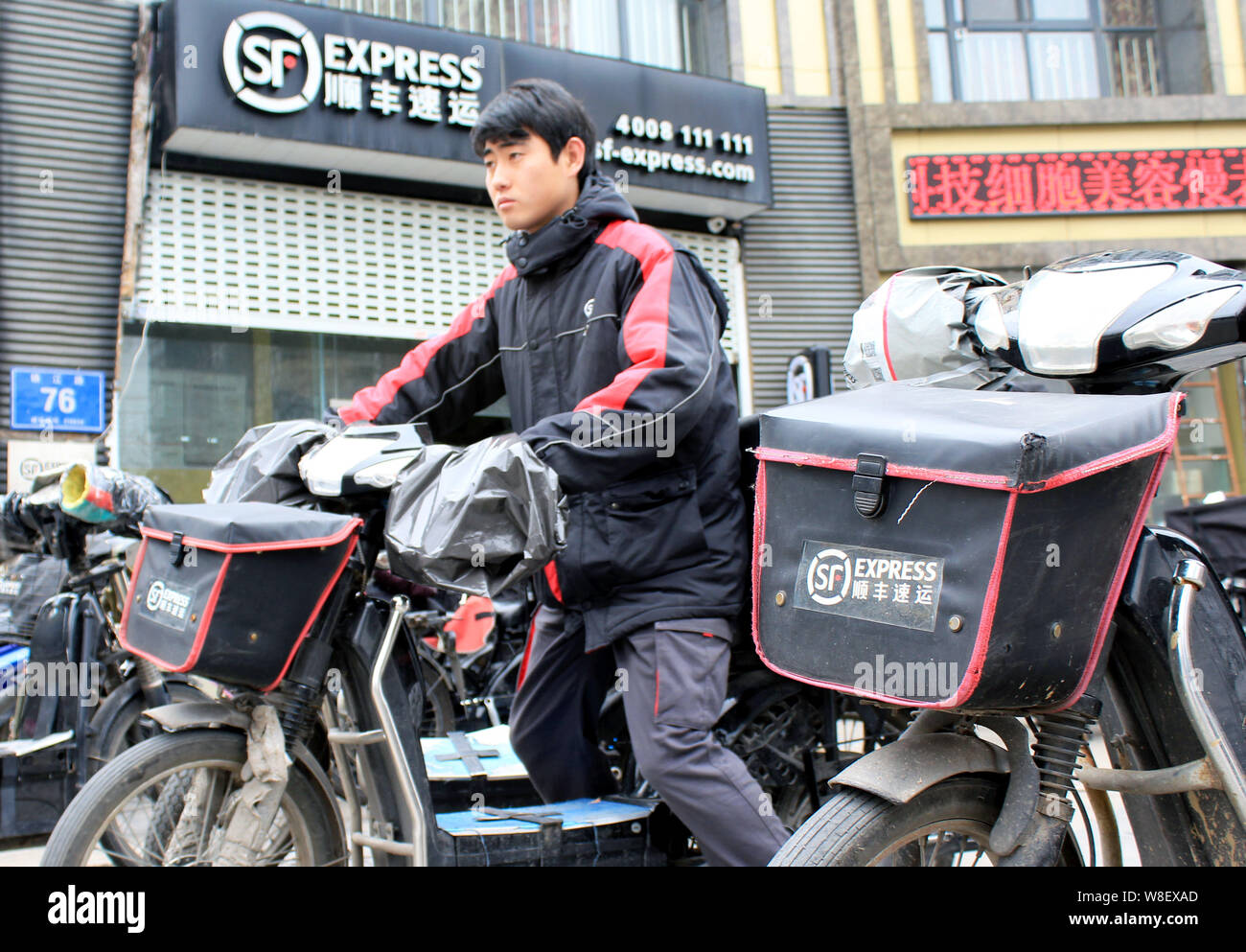 Un livreur chinois de SF Express chevauche son vélo électrique à partir d'un centre de distribution à Nanjing, Jiangsu province de Chine orientale, le 1 février Banque D'Images