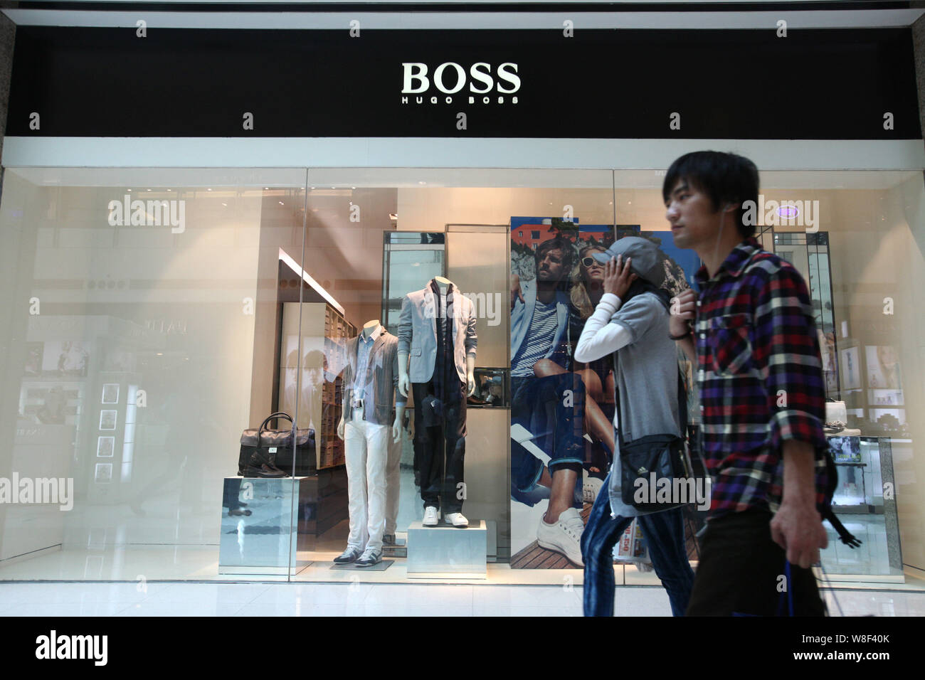 --FILE--piétons devant une boutique Hugo Boss à Shanghai, Chine, le 29 avril 2011. La marque allemande Hugo Boss AG a déclaré que l'année prochaine vente m Banque D'Images