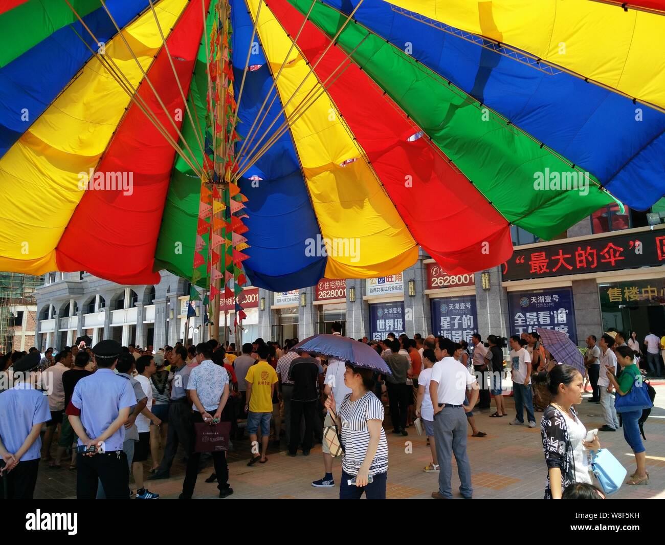 Les gens se tenir sous le parapluie le plus important au monde après qu'il a été certifié par le Guinness World Records en Xingzi, comté de Jiujiang, ville de la Chine est Jia Banque D'Images