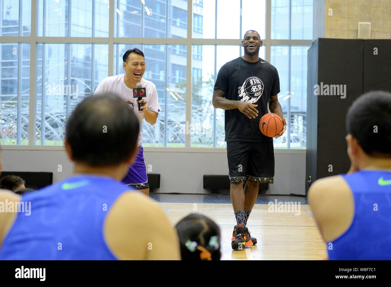 Star de la NBA LeBron James, le dos droit, demande à de jeunes enfants  chinois et autres participants à jouer au basket-ball à une activité sur le  campus par Nike à Shanghai,