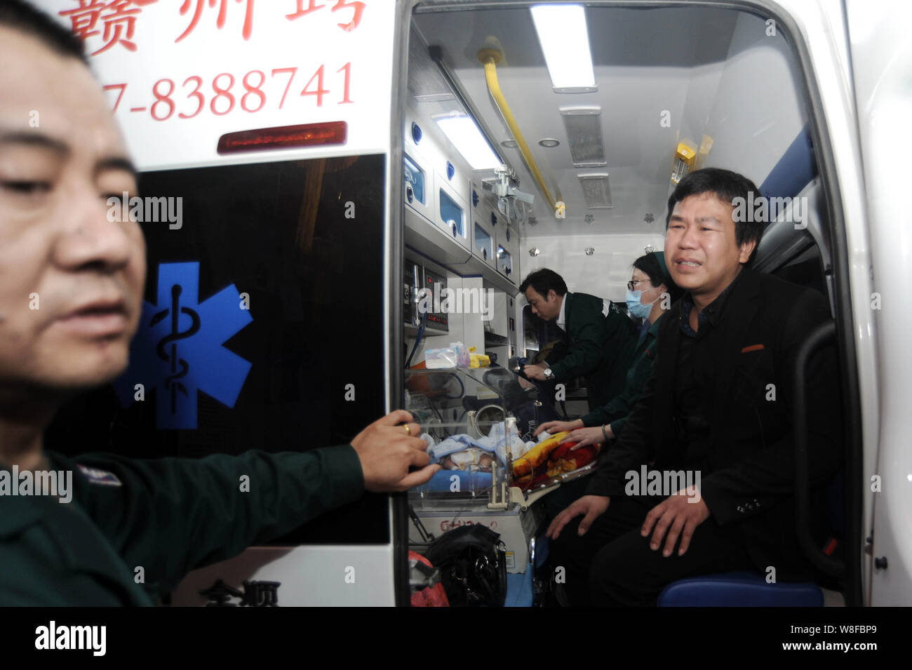 Le père angoissé, droite, de l'uni twin sisters est vu dans une ambulance avant qu'ils ont été transférés à l'Hôpital pour enfants de l'ONU de Fudan Banque D'Images