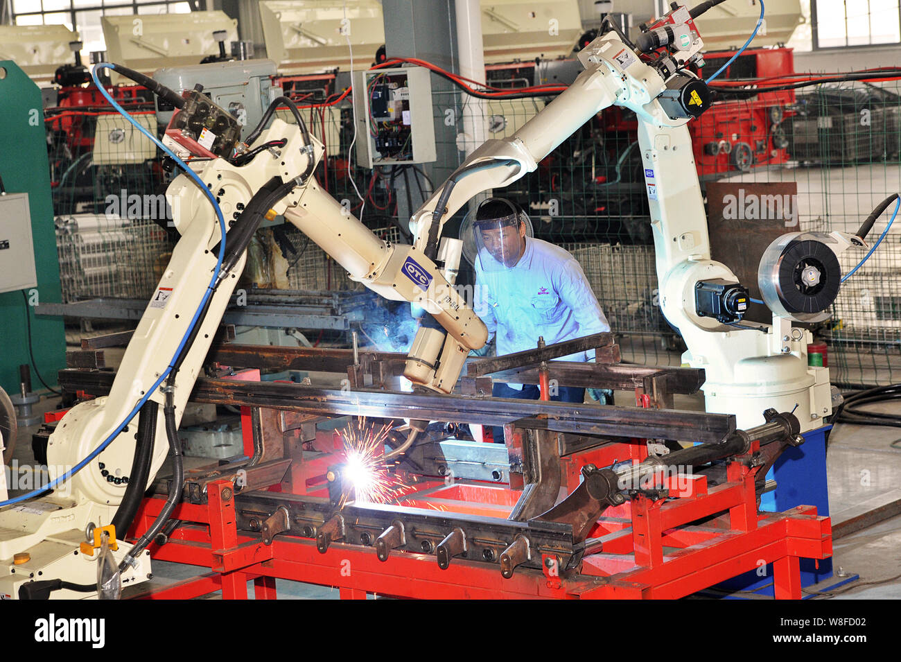 --FILE--Un travailleur chinois surveille les composants du robot de soudage d'armes de la récolte à l'usine de machines agricoles Furniture Co., Ltd. à Huzh Banque D'Images --FILE--Un travailleur chinois surveille les composants du robot de soudage d'armes de la récolte à l'usine de machines agricoles Furniture Co., Ltd. à Huzh Banque D'Images