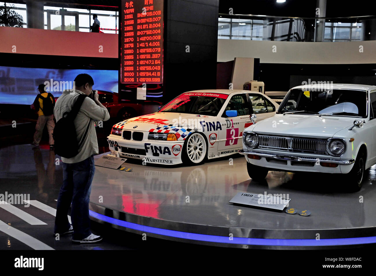 --FILE--un visiteur prend des photos d'une BMW 320i STW, gauche, et une Toyota Corolla sur l'affichage à la Musée de la voiture de Shanghai à Anting New Town, Shanghai, Chin Banque D'Images