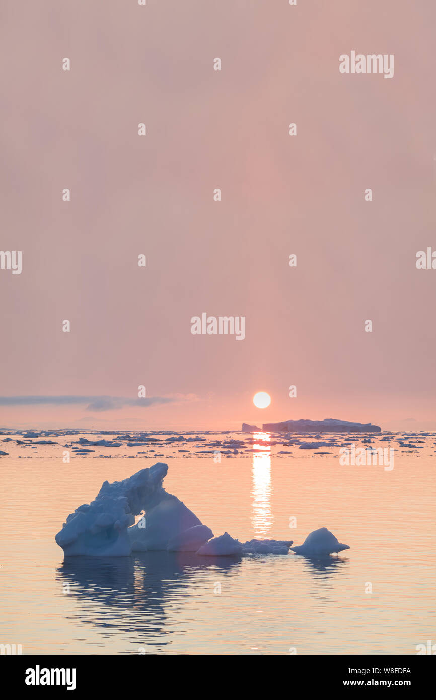 Nature Paysage arctique d'icebergs au Groenland avec midnight icefjord soleil coucher / Lever du soleil à l'horizon. Au cours de l'été tôt le matin alpenglow Banque D'Images