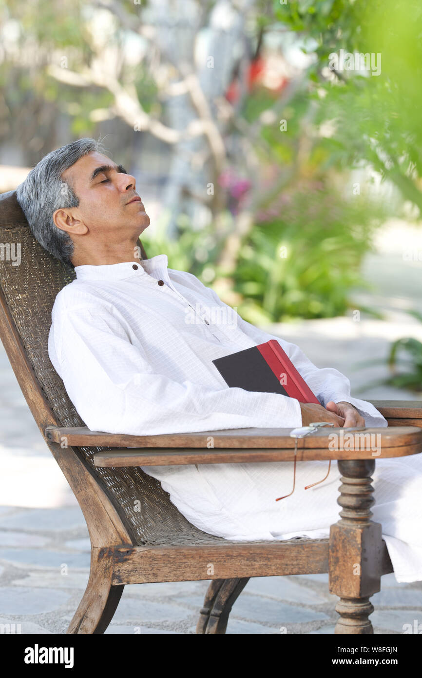 Homme senior se relaxant dans le jardin Banque D'Images