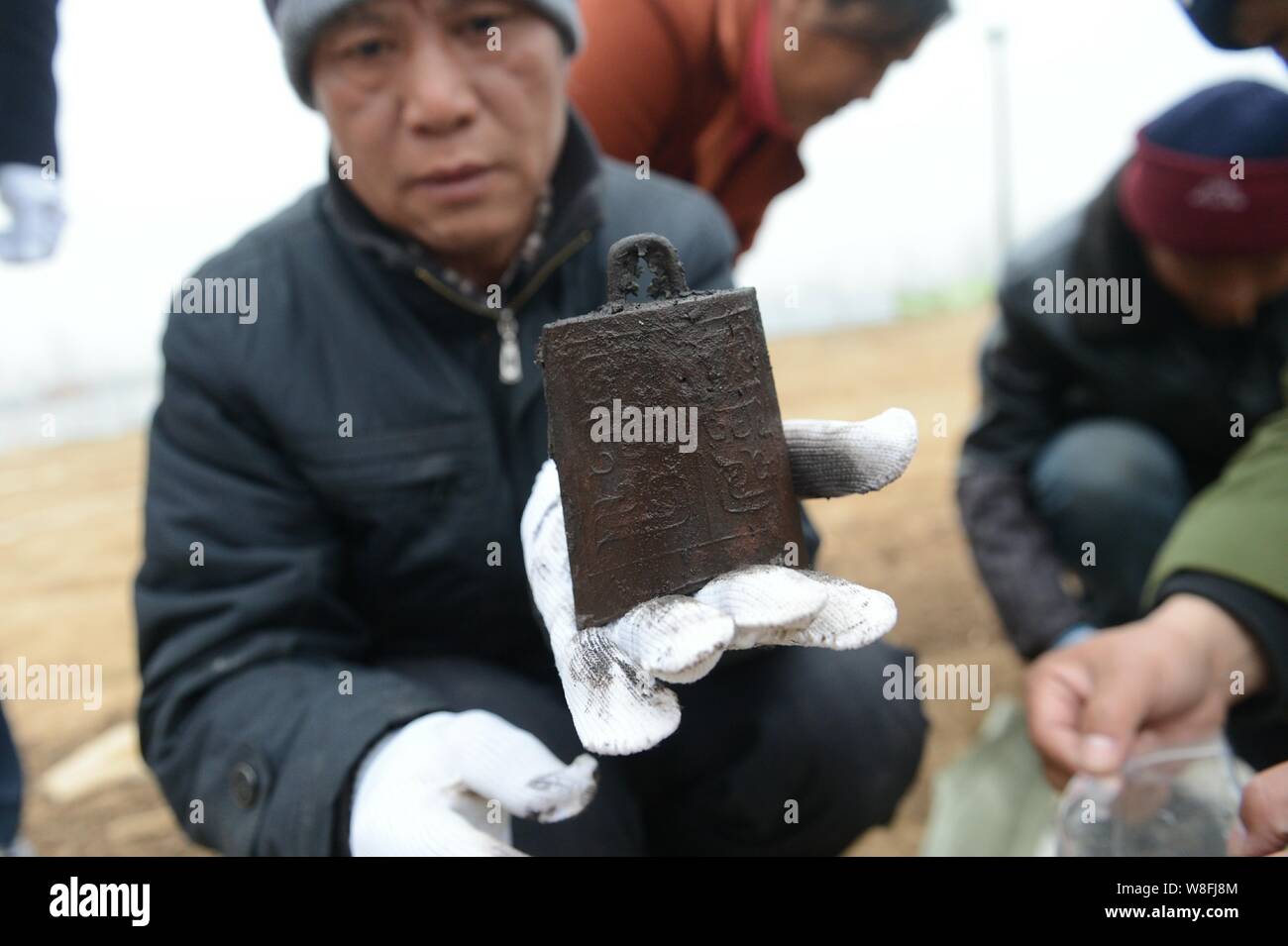 Un archéologue montre Bianzhong, un ancien instrument de musique chinois composé d'un ensemble de cloches en bronze, après l'excavation d'un tombeau datant b Banque D'Images