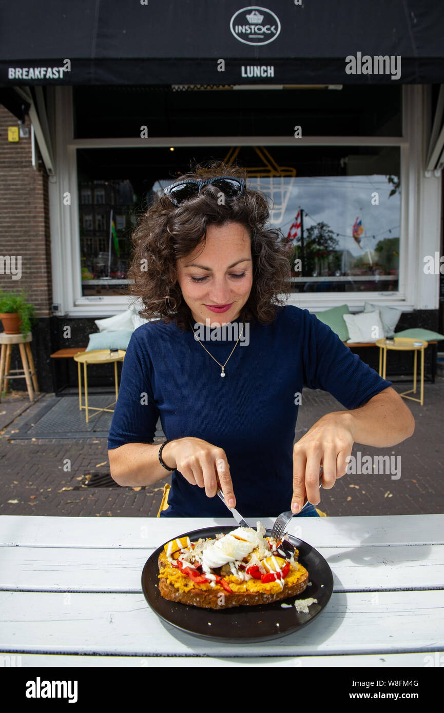 Den Haag. Een jonge vrouw met een gezonde déjeuner op een terras.. Foto : Gerrit de Heus. Les Pays-Bas. Une jeune femme ayant un déjeuner sain. Photo : G Banque D'Images