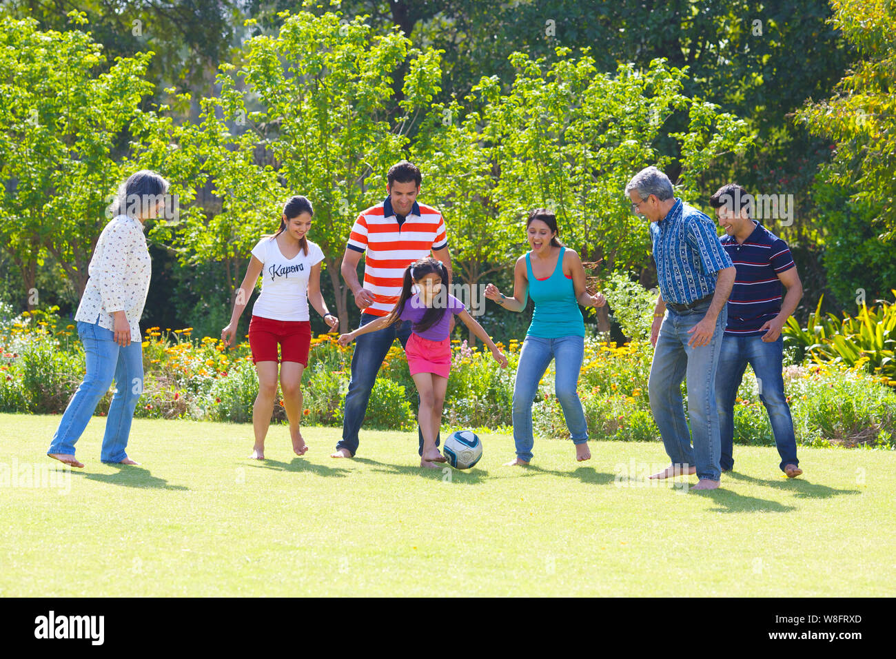 Family playing football in lawn Banque D'Images