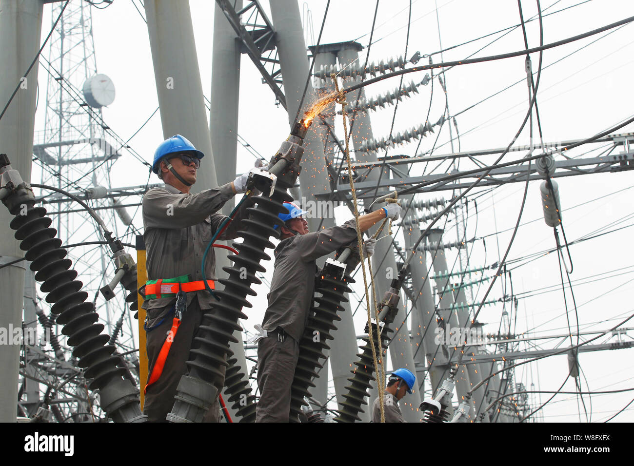 --FILE--électriciens chinois appareils électriques mise à jour à un poste de transformation Yichang city, province du Hubei en Chine centrale, 28 août 2015. Chi Banque D'Images