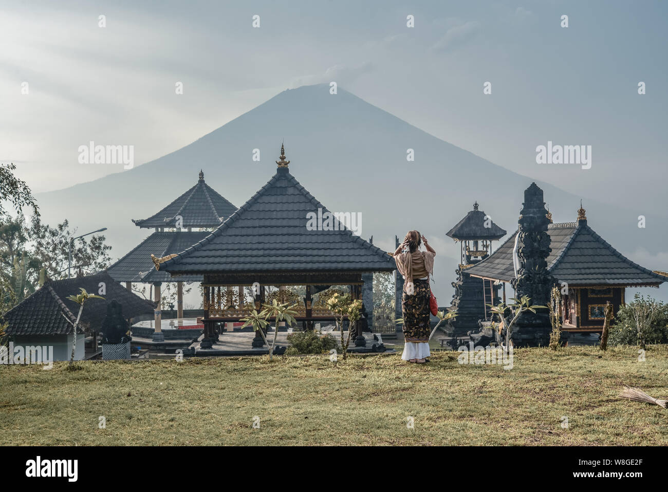 Femme près de temple de Lempuyang à Bali, Indonésie. Pura Penataran Agung. Lempuyang L'ancien et célèbre temple dans un style balinais avec une vue d'Agung volcan. Banque D'Images