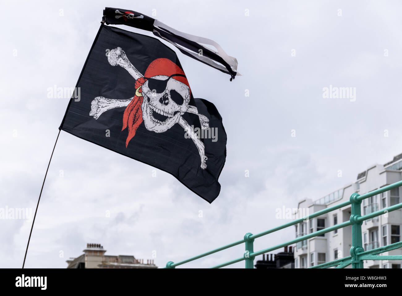 Jolly Roger drapeau à vent au-dessus du front de mer de Brighton, Sussex, Angleterre Banque D'Images