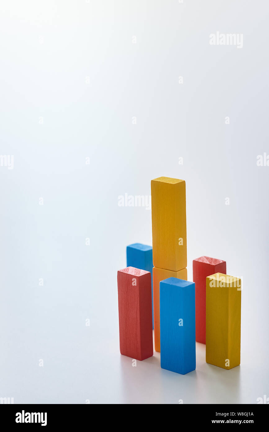 Rouge, bleu et jaune des blocs de bois de différentes hauteurs isolées sur fond blanc. Tableau de croissance. Schéma de l'infographie. Shot verticale Banque D'Images