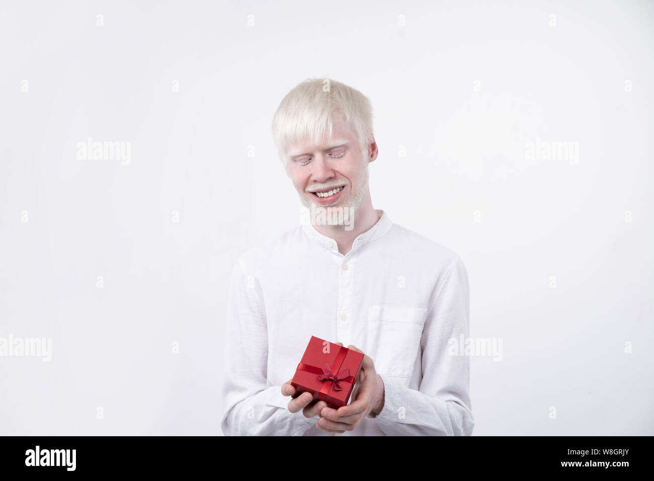 Portrait d'un homme albinos dans studio habillé t-shirt isolé sur un fond blanc. déviations anormales. Aspect insolite anomalie de la peau. Banque D'Images
