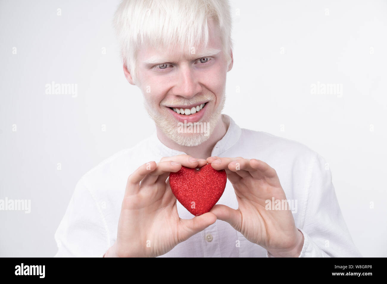 Portrait d'un homme albinos dans studio habillé t-shirt isolé sur un fond blanc. déviations anormales. Aspect insolite anomalie de la peau. Banque D'Images