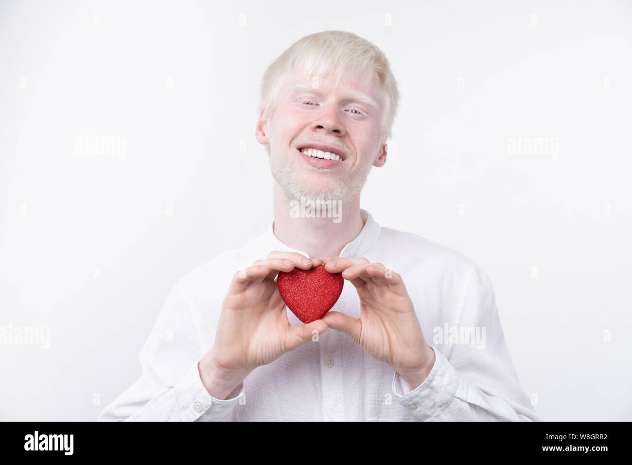 Portrait d'un homme albinos dans studio habillé t-shirt isolé sur un fond blanc. déviations anormales. Aspect insolite anomalie de la peau. Banque D'Images