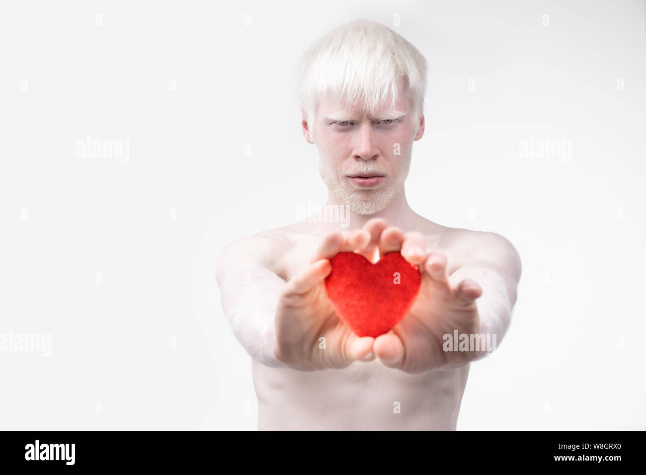 Portrait d'un homme albinos dans studio habillé t-shirt isolé sur un fond blanc. déviations anormales. Aspect insolite anomalie de la peau. Banque D'Images