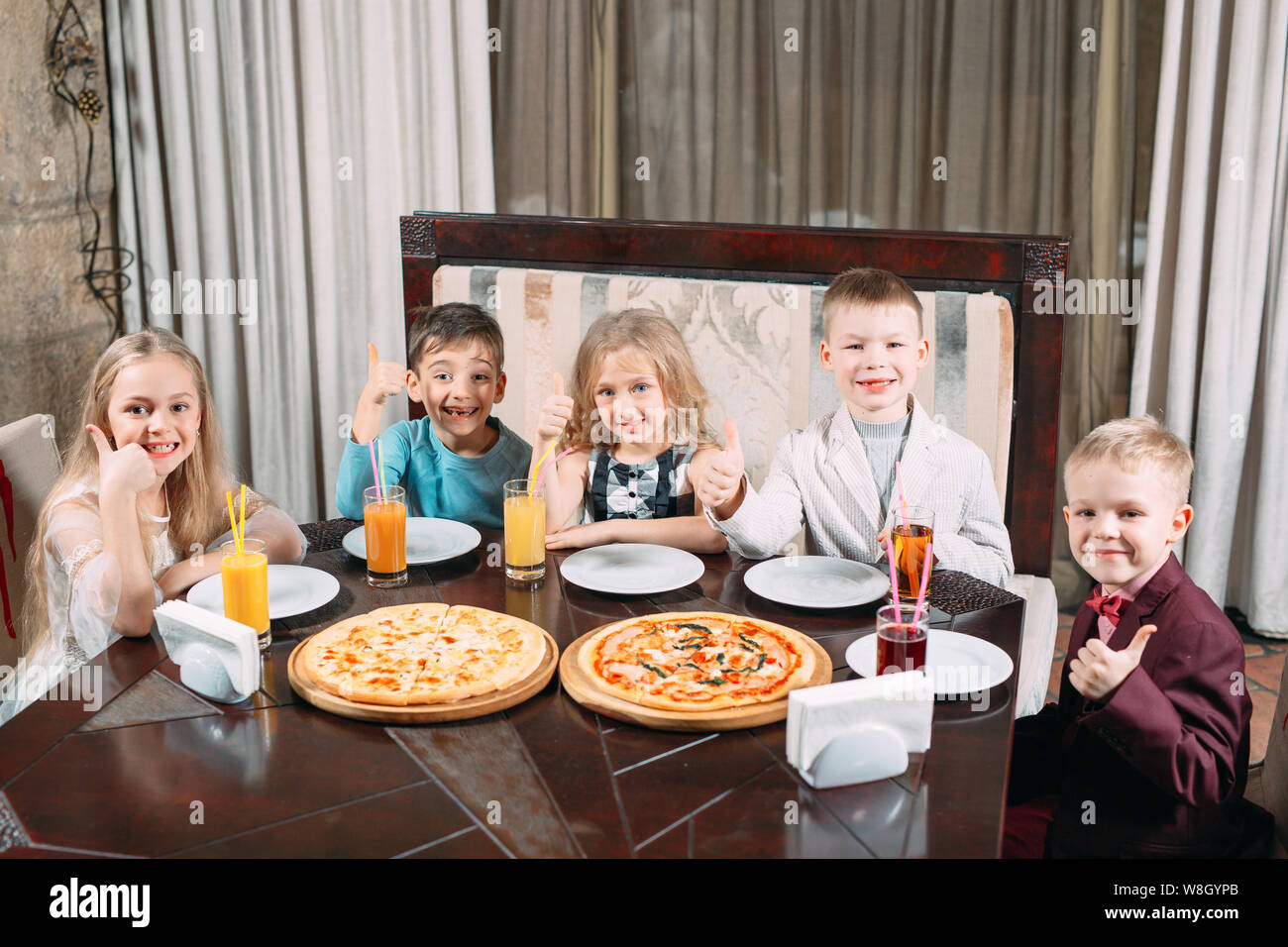 Groupe d'enfants manger une pizza au restaurant. Banque D'Images