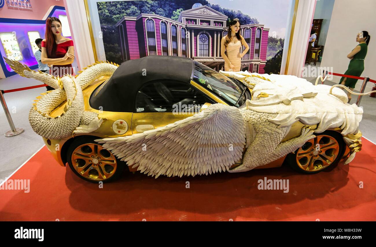 Les modèles posent avec une BMW Z4 avec de l'or et les os de yack, qui ressemble à un dragon, au cours de la China International Beauty Expo dans la ville de Guangzhou, de sorte Banque D'Images