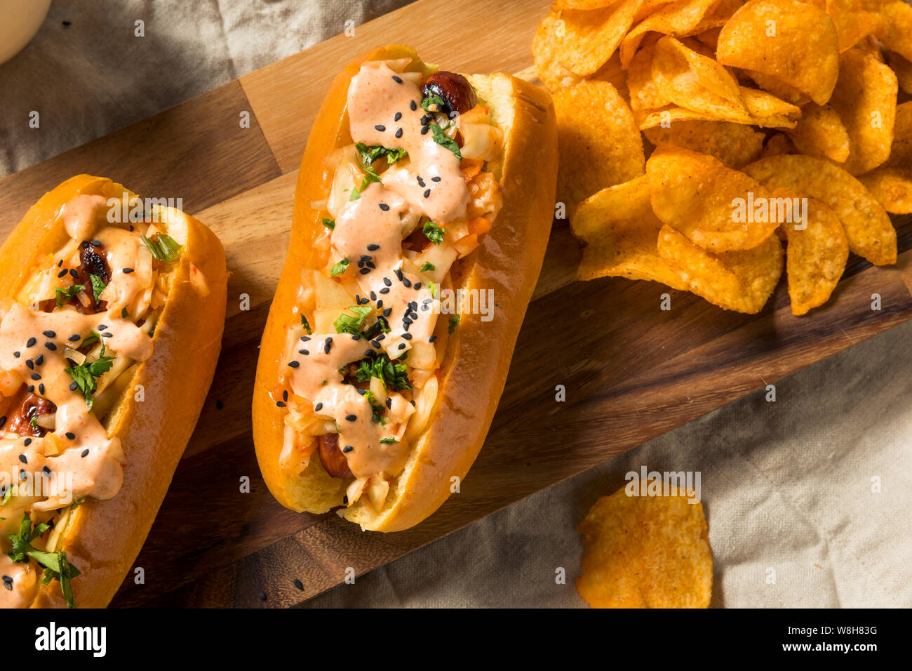 Kimchi coréen maison Hot Dog avec Sriracha et de graines de sésame Banque D'Images