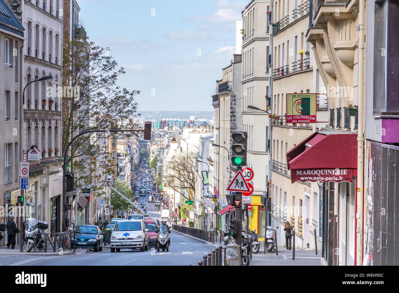 Paris, France - 15 Avril 2014 : l'Menilmontant Street (rue Menilmontant) à Paris avec quelques voitures et personnes walkint. Il est possible de voir le Beau Banque D'Images