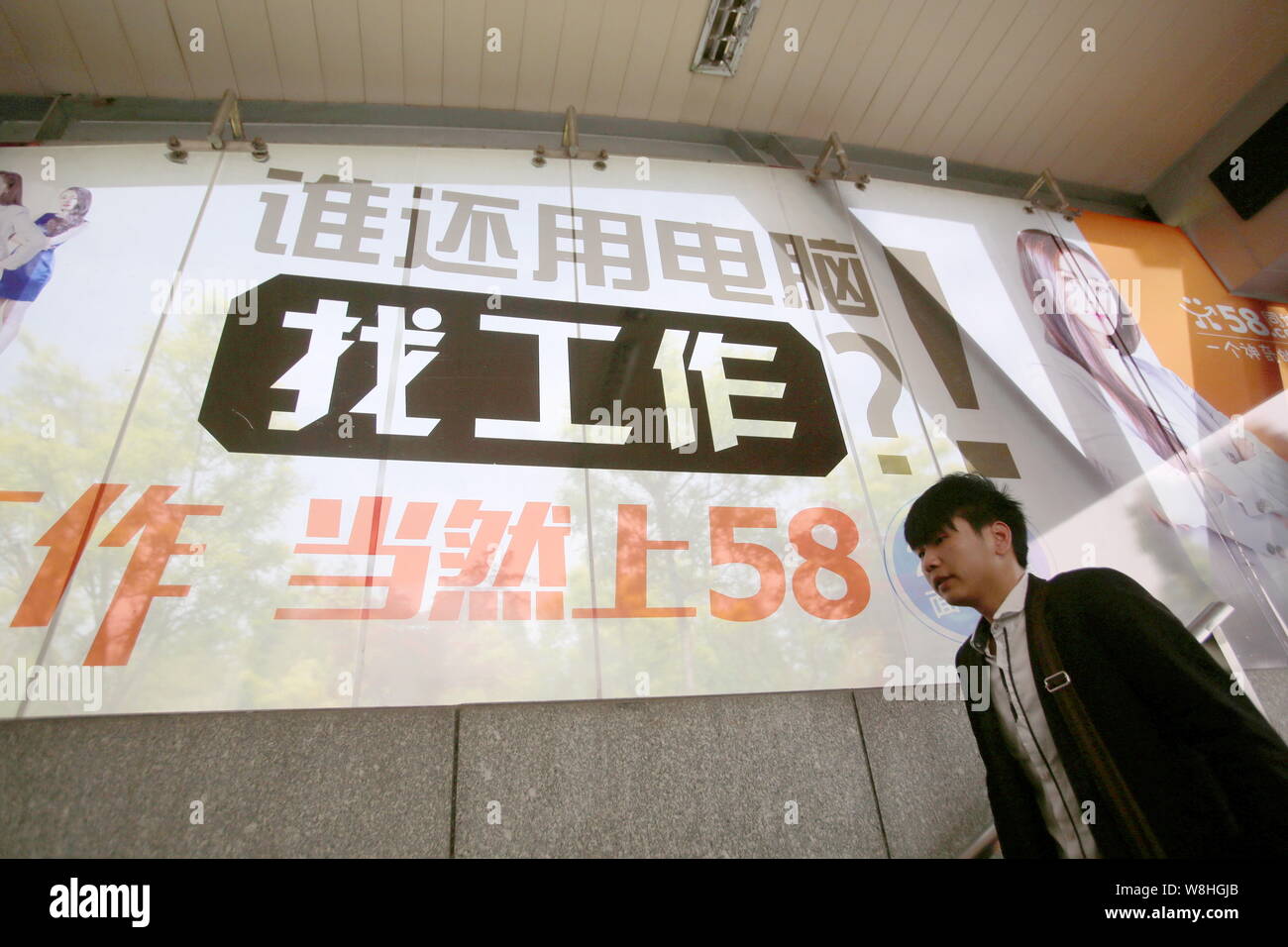 --FILE--un piéton passe devant une publicité pour site classé en ligne chinois 58.Com à Shanghai, Chine, le 27 avril 2015. Annonce classée chinois Banque D'Images