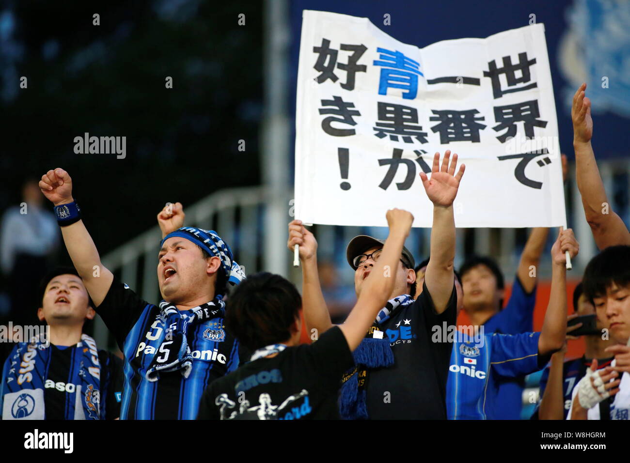 Des fans de football japonais crier des slogans pour manifester leur appui à la candidature du Japon Gamba Osaka lors d'un match du groupe F de la Ligue des Champions 2015 contre la Chine. Banque D'Images