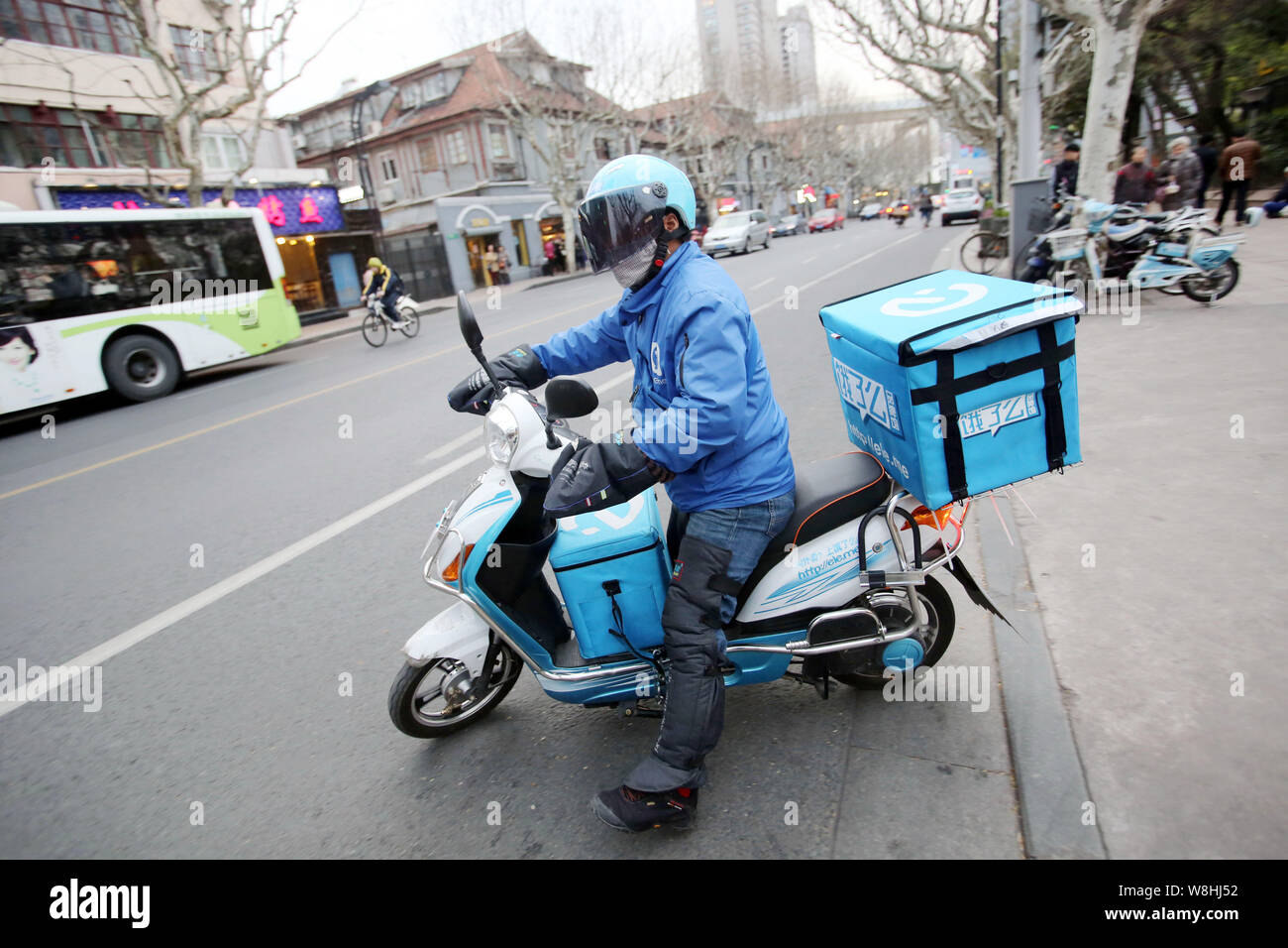--FILE--un livreur de nourriture chinoise société de livraison Ele.me rides un vélo électrique pour livrer des repas à Shanghai, Chine, 24 mars 2015. E de la Chine Banque D'Images