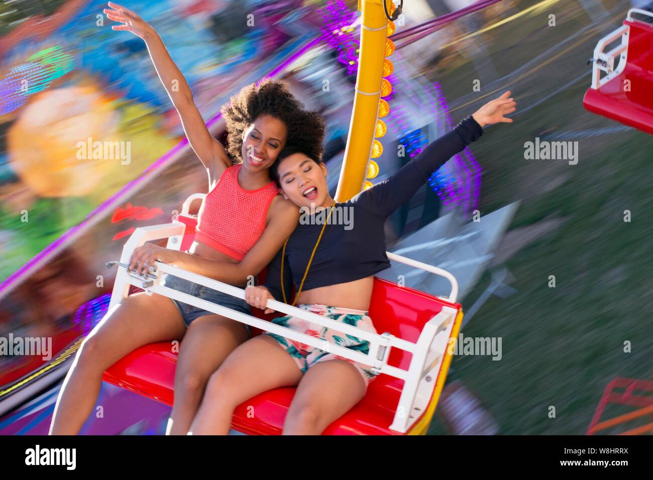 Deux jeunes femmes sur le parc d'amusement ride au juste. Banque D'Images