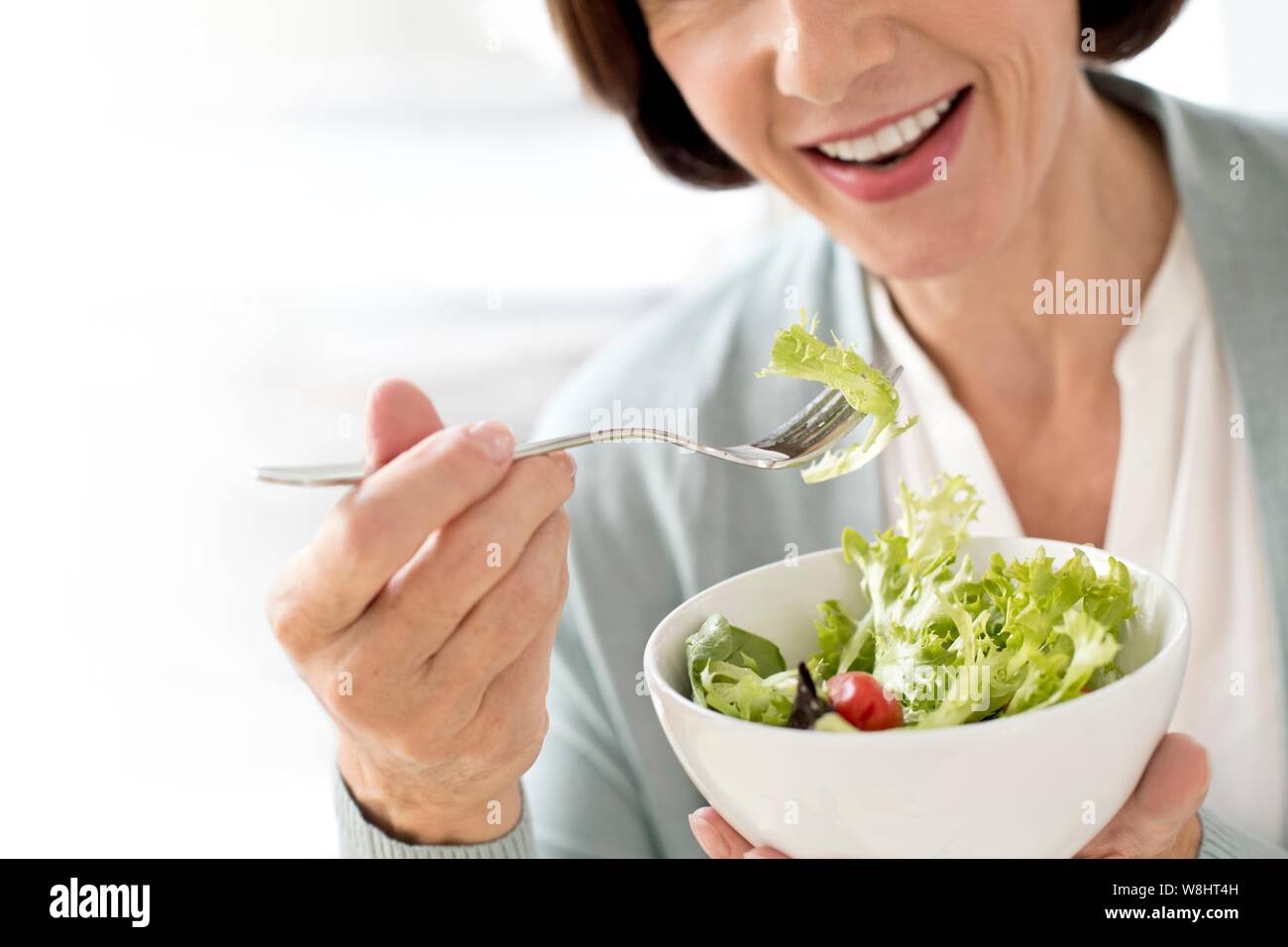 Young woman eating salad. Banque D'Images